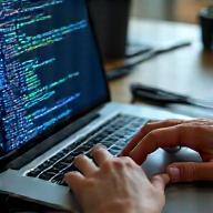 Hands-on laptop coding in modern workspace